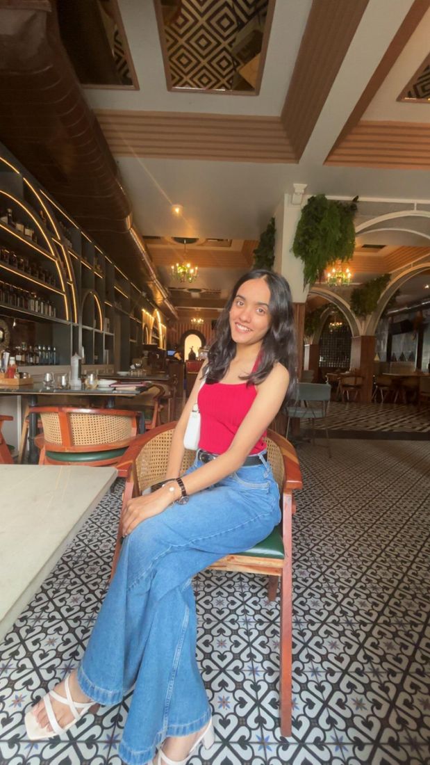 Anisha Khandelwal, founder of Aayena, sitting in a café